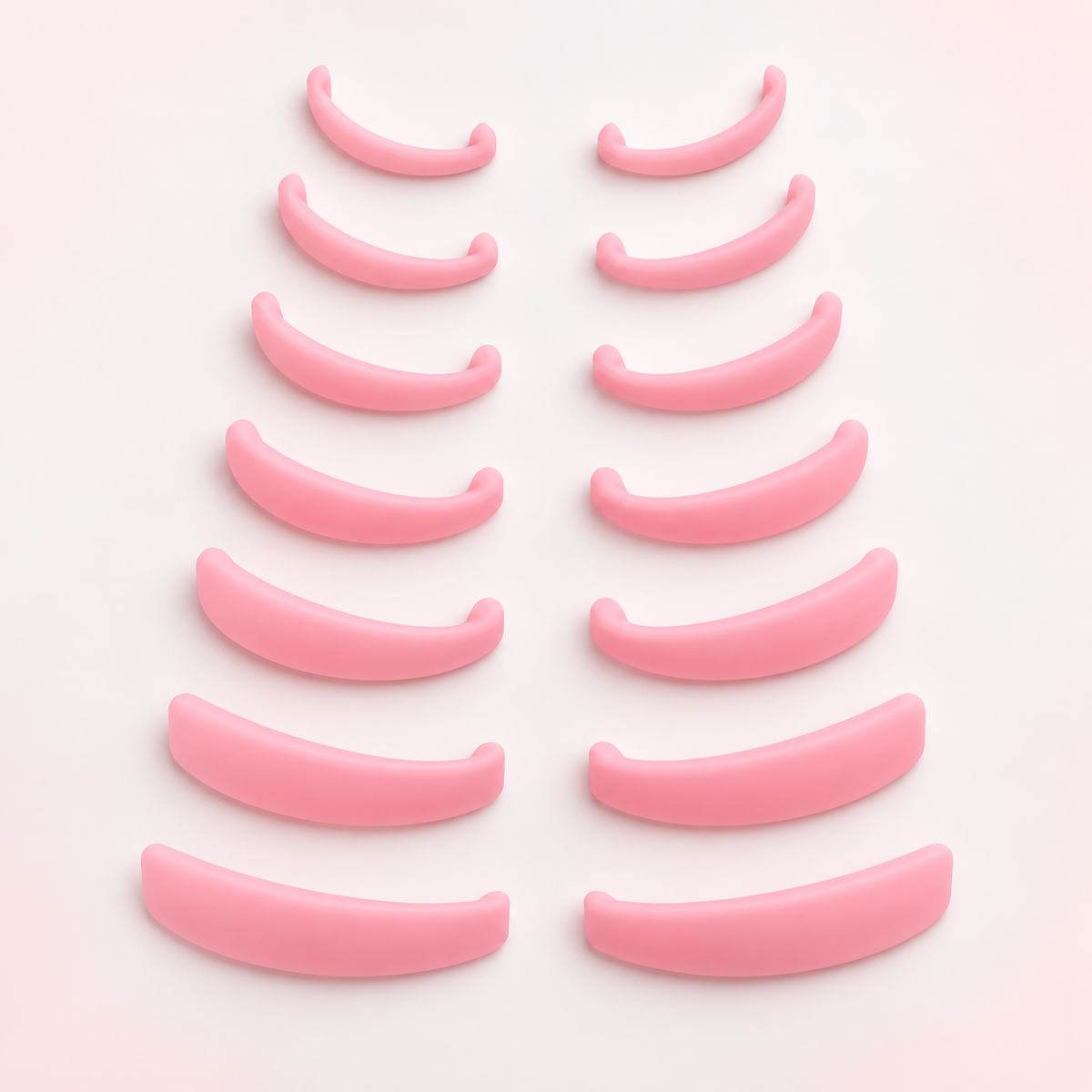 Fourteen pink silicone lash lift rods arranged in seven size pairs