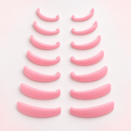 Fourteen pink silicone lash lift rods arranged in seven size pairs