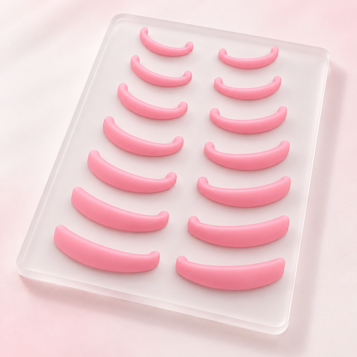 Fourteen pink silicone lash lift rods displayed on a frosted tray